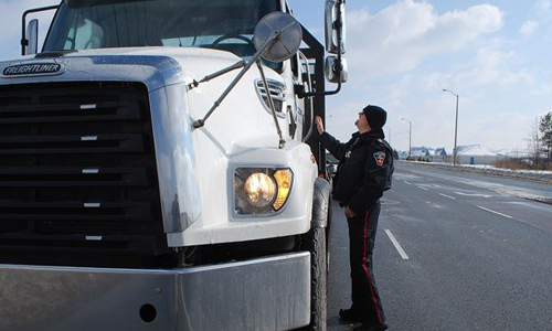 Pictured: Constable Phil Steward inspecting a tow truck in Whitby. Durham Police officers laid 59 charges in total over the two-day safety blitz, for infractions such as inoperative braking systems and load security.